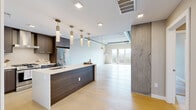 Located at 1515 Julian St in Denver's vibrant 80204 neighborhood, this thoughtfully designed one-bedroom, one-bathroom unit blends industrial character with contemporary elegance. The open-concept kitchen and living area serves as the heart of the home, showcasing light hardwood floors, exposed concrete ceilings with visible ductwork, and dramatic exposed concrete columns that lend an urban loft aesthetic. The kitchen is equipped with stainless steel appliances, dark wood cabinetry, a large center island with a white quartz countertop, an undermount sink, and a series of stylish brass pendant lights that add warmth and sophistication. The spacious living area benefits from floor-to-ceiling windows and sliding glass door access to a private balcony, inviting abundant natural light and open city views. The generously sized primary bedroom continues the loft-inspired design with exposed concrete ceilings, large windows overlooking the Denver skyline, and direct access to two well-appointed closets. The full bathroom features a freestanding soaking tub, a glass-enclosed walk-in shower, dual floating vanities with dark wood cabinetry and illuminated mirrors, and large-format tile flooring, creating a refined, spa-like retreat.