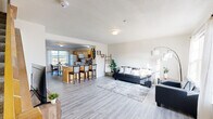 This 3-floor property in Ames, Iowa offers a thoughtfully laid-out living space ideal for comfortable, everyday living. The main level showcases an open-concept design connecting the living room, dining area, and kitchen. The living room features light gray laminate flooring, large windows that invite natural light, and generous space for seating. The kitchen is well-appointed with warm honey-toned wood cabinetry, gray laminate countertops, a double-basin sink, dishwasher, range, microwave, and refrigerator. A kitchen island with bar seating provides additional dining space. A staircase with wood railings connects all three levels. The bedrooms are carpeted and generously sized, each offering windows with outdoor views and ample closet space, including walk-in options. Bathrooms throughout the property feature clean, light-colored finishes with tub-shower combinations and vanity storage — one with updated gray laminate flooring and another with classic tile. The overall ambiance across all floors is bright, neutral, and move-in ready, with a clean, modern sensibility. Located in Ames, home to Iowa State University, this property is well-suited for a variety of living arrangements.