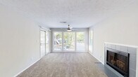 Located at 100 Summerwalk Parkway in Tucker, GA, this single-floor, 2-bedroom, 1-bathroom home offers a functional and well-appointed layout. The living room is a standout space, featuring large sliding glass doors and picture windows that flood the room with natural light and provide views of the surrounding greenery. A tiled fireplace anchors one wall, while a ceiling fan and textured ceiling add classic character. Soft carpeting extends throughout the living areas and bedrooms.

The kitchen is thoughtfully updated with white cabinetry, marble-look quartz countertops, a gray subway tile backsplash, wood-look flooring, and stainless steel appliances including a gas range and dishwasher. A window above the sink brings in natural light.

Both bedrooms are carpeted and equipped with ceiling fans and windows that invite outdoor views. The spacious primary bedroom offers ample room for furnishings. The bathroom features wood-look flooring, a tub-shower combo with tile surround, and a marble-look vanity countertop. A dedicated in-unit laundry area with full-size washer and dryer hookups adds everyday convenience. The home also includes a closet for additional storage.