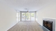 Located at 100 Summerwalk Parkway in Tucker, GA, this single-floor, 2-bedroom, 1-bathroom home offers a functional and well-appointed layout. The living room is a standout space, featuring large sliding glass doors and picture windows that flood the room with natural light and provide views of the surrounding greenery. A tiled fireplace anchors one wall, while a ceiling fan and textured ceiling add classic character. Soft carpeting extends throughout the living areas and bedrooms.

The kitchen is thoughtfully updated with white cabinetry, marble-look quartz countertops, a gray subway tile backsplash, wood-look flooring, and stainless steel appliances including a gas range and dishwasher. A window above the sink brings in natural light.

Both bedrooms are carpeted and equipped with ceiling fans and windows that invite outdoor views. The spacious primary bedroom offers ample room for furnishings. The bathroom features wood-look flooring, a tub-shower combo with tile surround, and a marble-look vanity countertop. A dedicated in-unit laundry area with full-size washer and dryer hookups adds everyday convenience. The home also includes a closet for additional storage.