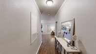 This single-story residence in Houma, Louisiana offers a thoughtfully designed layout with two bedrooms and two full bathrooms. The entryway features a wide hallway with wood-look flooring and crown molding, setting a clean, cohesive aesthetic that carries throughout the unit.

The living room is comfortably sized, accented with crown molding, a ceiling fan, and a door providing access to the exterior. Natural light filters in through slatted window blinds, creating a bright yet relaxed atmosphere. Adjacent to the living area, a defined dining nook offers an intimate space for meals.

The galley-style kitchen is well-equipped with rich wood cabinetry, granite-look countertops, stainless steel appliances, and durable wood-look flooring. A dedicated laundry area houses a full-size washer and dryer, adding everyday convenience.

Both bedrooms are carpeted and feature ceiling fans and crown molding, providing a quiet and comfortable retreat. Each bathroom is cleanly finished, with one including a tub-shower combination. The overall palette of warm neutrals and consistent finishes gives the space a cohesive, inviting character throughout.