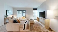 Located at 109 E Wilson St in the heart of Madison, WI, this thoughtfully designed one-bedroom, one-bathroom residence offers a clean, modern aesthetic across a well-utilized single floor. Light hardwood flooring flows throughout the main living areas, tying together a cohesive and contemporary look.

The open-concept kitchen and living room serve as the centerpiece of the unit. The kitchen is outfitted with sleek gray wood-grain cabinetry extending to the ceiling, stainless steel appliances including a refrigerator, over-the-range microwave, electric range, and dishwasher, complemented by a classic subway tile backsplash and dark countertops. The living area features large windows that invite natural light and views of the surrounding cityscape, creating a bright and welcoming atmosphere.

The bedroom is a calm, well-proportioned retreat with large floor-to-ceiling windows fitted with roller shades, allowing for flexible light control. The room comfortably accommodates a full bedroom set alongside a dedicated closet for storage.

The bathroom presents a refined, spa-like feel with large-format light tile flooring, a vanity with gray wood-grain cabinetry, dark countertops, and a backlit LED mirror that adds a polished finishing touch. Clean white walls throughout the unit reinforce the modern, understated design sensibility.