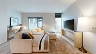 Located at 109 E Wilson St in the heart of Madison, WI, this thoughtfully designed one-bedroom, one-bathroom residence offers a clean, modern aesthetic across a well-utilized single floor. Light hardwood flooring flows throughout the main living areas, tying together a cohesive and contemporary look.

The open-concept kitchen and living room serve as the centerpiece of the unit. The kitchen is outfitted with sleek gray wood-grain cabinetry extending to the ceiling, stainless steel appliances including a refrigerator, over-the-range microwave, electric range, and dishwasher, complemented by a classic subway tile backsplash and dark countertops. The living area features large windows that invite natural light and views of the surrounding cityscape, creating a bright and welcoming atmosphere.

The bedroom is a calm, well-proportioned retreat with large floor-to-ceiling windows fitted with roller shades, allowing for flexible light control. The room comfortably accommodates a full bedroom set alongside a dedicated closet for storage.

The bathroom presents a refined, spa-like feel with large-format light tile flooring, a vanity with gray wood-grain cabinetry, dark countertops, and a backlit LED mirror that adds a polished finishing touch. Clean white walls throughout the unit reinforce the modern, understated design sensibility.