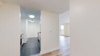 Located at 685 West Broadway in Monticello, NY, this well-designed two-bedroom, two-bathroom residence offers a thoughtfully organized single-floor layout with a clean, modern aesthetic throughout. Light-toned hardwood flooring runs through the living areas and bedrooms, complementing the bright, neutral color palette that gives the space an open and airy feel.

The galley-style kitchen is efficiently laid out with white cabinetry, dark countertops, stainless steel appliances including an electric range and dishwasher, and a sleek tile floor — offering both style and functionality. The combined dining and living area is generously proportioned, featuring multiple windows and a door leading directly to a private patio, filling the space with natural light and providing easy outdoor access.

The spacious primary bedroom includes a walk-in closet with wire shelving systems and views to the outside. The second bedroom also benefits from natural light through its window and offers a built-in closet. Both bedrooms feature the same warm hardwood flooring found throughout.

One bathroom stands out with a corner soaking tub, mosaic tile flooring, and large-format wall tiles, creating a refined, spa-like atmosphere. A dedicated laundry area and five total closets round out this well-equipped and storage-rich residence.