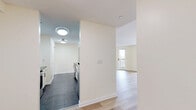 Located at 685 West Broadway in Monticello, NY, this well-designed two-bedroom, two-bathroom residence offers a thoughtfully organized single-floor layout with a clean, modern aesthetic throughout. Light-toned hardwood flooring runs through the living areas and bedrooms, complementing the bright, neutral color palette that gives the space an open and airy feel.

The galley-style kitchen is efficiently laid out with white cabinetry, dark countertops, stainless steel appliances including an electric range and dishwasher, and a sleek tile floor — offering both style and functionality. The combined dining and living area is generously proportioned, featuring multiple windows and a door leading directly to a private patio, filling the space with natural light and providing easy outdoor access.

The spacious primary bedroom includes a walk-in closet with wire shelving systems and views to the outside. The second bedroom also benefits from natural light through its window and offers a built-in closet. Both bedrooms feature the same warm hardwood flooring found throughout.

One bathroom stands out with a corner soaking tub, mosaic tile flooring, and large-format wall tiles, creating a refined, spa-like atmosphere. A dedicated laundry area and five total closets round out this well-equipped and storage-rich residence.