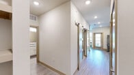 This efficiently designed 2-bedroom, 1-bathroom residence in Grand Prairie, Texas offers a thoughtfully arranged single-floor layout that maximizes every square foot. The interior is finished with light-toned hardwood-style flooring throughout the main living areas, complemented by neutral walls and recessed lighting that create a bright, welcoming atmosphere.

The kitchen is a standout feature, showcasing crisp white cabinetry with brushed nickel hardware, granite-look countertops, a classic subway tile backsplash, and a full suite of stainless steel appliances including a refrigerator, range, and over-the-range microwave. A stainless steel sink with a modern faucet completes the functional workspace, and a door provides convenient access to an outdoor area.

The hallway leading to the bedrooms is equipped with stylish sliding barn doors featuring frosted glass panels, adding a contemporary design element while offering privacy. The bedrooms are carpeted for comfort, with the primary bedroom offering a cozy, well-proportioned retreat.

The bathroom includes a soaking tub surrounded by large-format neutral tile, providing a clean and relaxing space. Throughout the residence, the design emphasizes modern, low-maintenance finishes in a cohesive, neutral palette that lends itself to a variety of furnishing styles.