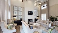 This stylish clubhouse offers a refined communal environment defined by its dramatic vaulted ceilings and carefully curated design details. The main gathering area is anchored by a floor-to-ceiling shiplap accent wall housing a sleek fireplace, creating a striking focal point that blends farmhouse charm with contemporary elegance. A wall-mounted flat-screen television above the fireplace adds a functional element without disrupting the aesthetic cohesion of the space.

The seating arrangement features plush, neutral-toned sofas and armchairs paired with a round marble-top coffee table accented with gold metal legs, conveying a sense of refined comfort. Dark, fluted credenzas positioned on either side of the room provide a bold contrast to the bright, white walls and light hardwood flooring. Botanical botanical artwork displayed in matching frames adds a natural, organic touch throughout.

Overhead, a grand circular chandelier with candle-style lighting serves as a central design statement, while ceiling fans ensure year-round comfort. Sheer floor-to-ceiling drapery filters abundant natural light from large windows, enhancing the airy, open ambiance. The overall atmosphere is welcoming, polished, and thoughtfully designed to provide a premium communal experience.
