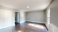 Located at 227 Washington Ave in Blackwood, NJ, this single-floor, 2-bedroom, 1-bathroom unit offers a thoughtfully laid-out living space with a clean, modern aesthetic throughout. The living room welcomes natural light through a large window and features rich, dark hardwood-style flooring, neutral gray walls, and white trim — a combination that lends a bright and cohesive feel to the space. The kitchen is equipped with rich dark-wood cabinetry, a classic white subway tile backsplash, light stone countertops, and a stainless steel sink, all set atop light-toned tile flooring. The primary bedroom is a well-proportioned room with dark hardwood-style floors, soft gray walls, and a set of white double closet doors offering ample storage. The second bedroom features light hardwood-style flooring, a window with outdoor tree views, and baseboard heating with a wall-mounted AC unit. The full bathroom includes a tub-shower combination dressed in white subway tile, accented by a decorative mosaic border in blue and neutral tones, with tile flooring completing the clean finish. A hallway and dedicated closet round out the floor plan, providing additional organization and flow throughout the home.