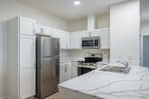 Located at 1028A Bindl Dr in Reedsburg, WI, this single-floor, 3-bedroom, 2-bathroom home offers a clean, modern design with a bright and cohesive aesthetic throughout. The open-concept kitchen and living area serves as the heart of the home, showcasing white shaker cabinetry, stainless steel appliances including a refrigerator, range, and microwave, and a central island with striking marble-look quartz countertops and a double-basin sink. Light luxury vinyl plank flooring runs through the main living areas, complementing the recessed lighting and crisp white walls.

The three bedrooms offer a comfortable retreat, with some featuring soft carpet flooring, ceiling fans, and windows that invite natural light. The primary bedroom provides a private and functional space, supported by generous closet storage — five closets are distributed throughout the home. The two bathrooms are finished with light vinyl flooring and include a tub/shower combination. A dedicated laundry area adds everyday convenience, while the entrance and hallway provide a smooth flow between spaces. A patio extends the living area outdoors, ideal for relaxing. This well-appointed home balances practicality with modern finishes throughout.