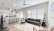 Located at 11100 Domain Dr in Jacksonville, FL, this well-appointed 2-bedroom, 2-bathroom residence offers a thoughtfully designed single-floor layout with modern finishes throughout. Light wood-style flooring flows seamlessly from room to room, complemented by a neutral color palette that enhances the bright, airy ambiance.

The open-concept living and kitchen area serves as the heart of the home. The living room features vaulted ceilings, a ceiling fan, and a wall of large windows that flood the space with natural light. The kitchen is a standout, boasting white shaker cabinetry, a white quartz waterfall island with bar seating, stainless steel appliances, subway tile backsplash, and dramatic pendant lighting.

The primary bedroom is a comfortable retreat with a ceiling fan, natural light from large windows, and access to a spacious walk-in closet outfitted with wire shelving. The second bedroom also features a ceiling fan, natural light, and dual closets. Both bathrooms are finished with white cabinetry, quartz countertops, and wood-look tile flooring, with one featuring a glass-enclosed walk-in shower. A hallway connects all spaces efficiently, completing this clean and functional floor plan.