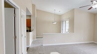 Located at 2221 Hyde Dr in Greenville, NC, this single-floor, 2-bedroom, 3-bathroom home offers a well-organized layout with a variety of functional spaces. The living room serves as the focal point of the home, showcasing vaulted ceilings, a ceiling fan, a bay window that invites natural light, and a tile-surround fireplace — creating a warm and open atmosphere. A half-wall partition separates the living area from the dining space, which features a pendant light fixture and a sliding glass door providing outdoor access. The kitchen is well-equipped with warm wood cabinetry, dark granite-style countertops, and black appliances including a refrigerator, electric range, and dishwasher, all set on wood-look flooring. Both bedrooms are generously sized, finished with plush carpet and natural light through blinded windows, and feature textured ceilings. The primary bedroom offers a spacious layout. The bathrooms include warm wood vanities with white countertops and wood-look flooring. A dedicated closet space houses a full-size washer and dryer, adding everyday convenience. Neutral beige tones throughout the home create a cohesive, move-in-ready aesthetic.