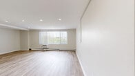 Located at 100 Old York Road in Jenkintown, PA, this well-designed three-bedroom, two-bathroom residence offers a comfortable and functional single-floor layout. Light-toned hardwood flooring flows throughout the living spaces and bedrooms, lending a clean, modern aesthetic to the interior.

The living room is generously sized, featuring recessed lighting, a wall-unit air conditioner, and a large picture window dressed with vertical blinds that frames pleasant outdoor greenery views and fills the room with natural light. Baseboard heating runs along the perimeter, providing efficient climate control.

The kitchen is thoughtfully equipped with warm wood cabinetry, granite countertops, tile flooring, and a full suite of stainless steel appliances including a gas range, over-the-range microwave, refrigerator, and dishwasher — offering both style and practicality.

The spacious primary bedroom provides ample room for furnishings, while a dedicated closet features wrap-around wire shelving and hanging rods, maximizing storage capacity. The additional bedrooms are well-proportioned with the same light hardwood flooring. The bathrooms include a full tub-shower combination with white tile surround and gold-tone fixtures. Two hallways connect the rooms efficiently throughout the residence's thoughtfully arranged floor plan.