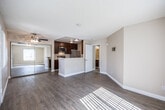 Located in Imperial Beach, CA, this one-bedroom, one-bathroom unit offers a thoughtfully designed single-level layout. The open-concept living, dining, and kitchen area forms the heart of the space, finished with warm wood-look laminate flooring and neutral-toned walls that create a bright, welcoming atmosphere. Natural light streams in through vertical-blind-clad windows flanking the front entry door, enhancing the airy feel of the living area.

The kitchen is a standout feature, with rich dark wood cabinetry lining both sides of the galley-style space. Stainless steel appliances — including a range, microwave, refrigerator, and dishwasher — are complemented by light countertops and a double-basin sink. A peninsula counter connects the kitchen to the living and dining area, ideal for casual dining or entertaining.

The generously sized bedroom features plush carpeting, a large window with ample natural light, and access to multiple closets for substantial storage. The full bathroom is well-appointed with a tub/shower combination, a dark wood vanity with a light countertop, and wood-look flooring that ties cohesively to the rest of the unit. Textured ceilings are consistent throughout, adding a classic residential character to the home.