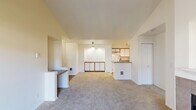 Located at 308 NE Autumn Rose Way in Hillsboro, Oregon, this single-floor, 3-bedroom, 2-bathroom home offers a well-organized layout designed for comfortable everyday living. The open living area is a standout feature, anchored by a tile-surround fireplace with a built-in niche above and vaulted ceilings that lend a sense of openness. A sliding glass door fills the space with natural light and provides direct access to a private balcony with outdoor views. The kitchen is efficiently designed with white cabinetry accented by warm wood trim, a full suite of white appliances, track lighting, and a peninsula with a sink that opens to the living and dining area. Plank-style flooring runs through the kitchen, while plush carpet covers the living areas and bedrooms. The three bedrooms each feature vaulted or elevated ceilings, carpeted floors, and windows that invite natural light. The primary bedroom connects to a full bathroom with a single vanity, countertop sink, wood-finish flooring, and a tub-shower combination. A second full bathroom mirrors a similar clean and functional design. A dedicated laundry room includes in-unit washer and dryer and additional built-in shelving for storage. Two closets and two hallways complete this thoughtfully arranged home.
