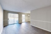 Located at 2909 Campbellton Rd SW in Atlanta, Georgia, this single-story, 2-bedroom, 3-bathroom home offers a practical and well-organized layout throughout. Wood-look plank flooring flows consistently across the living areas, bedrooms, kitchen, and hallway, creating a cohesive aesthetic. The living room is generously sized, featuring a sliding glass door with vertical blinds that invites natural light and provides outdoor access, complemented by a second window for added brightness. A decorative chandelier accents the adjoining dining area, separated by a subtle architectural transition. The kitchen is efficiently arranged in a galley style, outfitted with warm honey-toned cabinetry, dark granite-style countertops, a double sink, and black appliances including a refrigerator and electric range. A central hallway with a textured ceiling connects the bedrooms and bathrooms, maintaining a clean, functional flow. The primary bedroom is a comfortable size and includes access to a dedicated closet with built-in shelving. The bathrooms are finished with warm wood-toned vanities, large mirrors with overhead lighting, and tub-shower combinations. Throughout the home, neutral gray-toned walls, white six-panel doors, and clean white baseboards contribute to a bright, move-in-ready presentation.