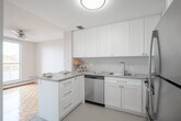 Located at 33 Leaside Dr in St. Catharines, Ontario, this 2-bedroom, 1-bathroom unit offers a well-organized and functional layout across a single floor. A bright, clean hallway with sliding storage doors and tile flooring serves as the entry point, leading into the main living areas. The combined living and dining room is generously proportioned, featuring classic parquet hardwood flooring and a ceiling fan, with large windows that invite abundant natural light and views of surrounding greenery. An adjacent dedicated dining area provides additional flexibility for everyday living. The kitchen is thoughtfully appointed with white shaker-style cabinetry, grey countertops, a subway tile backsplash, a stainless steel sink, and a stainless steel dishwasher, offering ample storage and counter space throughout. The primary bedroom is a comfortable, sun-filled room with parquet flooring and a window overlooking mature trees, while the second bedroom offers similar brightness and warmth. The full bathroom features a tiled tub-shower combination. A private balcony extends the living space outdoors. The unit's clean, neutral palette and consistent finishes contribute to a bright and welcoming overall ambiance.