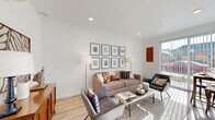 Located at 4915 N Vancouver Ave in Portland's vibrant Overlook neighborhood, this thoughtfully designed one-bedroom, one-bathroom unit makes excellent use of its compact footprint across a single floor. The open-plan kitchen and living area serves as the heart of the home, bathed in natural light from a large window. The living space features light wood flooring, recessed lighting, and a clean white palette that creates an airy, modern ambiance. The kitchen is outfitted with floor-to-ceiling white cabinetry, a subway tile backsplash, quartz countertops, and stainless steel appliances including a range, microwave, and dishwasher — combining style with full functionality. A hallway connects the main living area to the private bedroom, which is carpeted and equipped with a ceiling fan. Two closets provide ample storage, with one featuring a full wall of built-in cabinetry. The entrance offers a welcoming transition into the unit, with light wood flooring continuing throughout the common areas. A wall-mounted mini-split unit ensures year-round climate comfort. The clean, contemporary design and efficient layout make this a well-appointed urban residence in a prime Portland location.