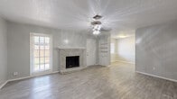 Located at 8623 Starcrest Dr in San Antonio, Texas, this well-appointed two-bedroom, three-bathroom single-story home offers a comfortable and functional layout. Light wood-look flooring flows throughout the entire space, creating a cohesive and modern feel. The spacious living room serves as the heart of the home, anchored by a classic white-painted brick fireplace and complemented by built-in shelving with cabinetry — ideal for storage and display. A ceiling fan and multiple windows allow natural light to fill the room, while an adjacent bay window area adds a bright, open nook perfect for a dining space or reading corner. The kitchen features white cabinetry, dark countertops, and black appliances, with a galley-style layout that maximizes efficiency. Both bedrooms are generously sized, each featuring ceiling fans, neutral gray walls, and windows that invite natural light. The primary bedroom is notably spacious and connects to a bathroom with dark granite countertops, a vessel sink, and white cabinetry. The additional bathrooms are equally well-finished, featuring tub-shower combinations and matching granite vanities. Textured ceilings are present throughout, adding a layer of classic character to this move-in-ready San Antonio home.
