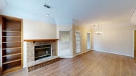 This single-story, one-bedroom, one-bathroom home in Columbus, Georgia offers a well-organized layout across a comfortable footprint. The living room serves as the centerpiece of the home, featuring warm hardwood-style flooring, a classic brick fireplace with a wood mantel, built-in shelving, crown molding, a textured ceiling, and a chandelier that adds a touch of elegance. Multiple windows with blinds allow natural light to fill the space, creating a bright and welcoming atmosphere. The kitchen is efficiently designed with ample warm-toned wood cabinetry, white countertops, a peninsula breakfast bar, and includes a refrigerator, electric range, built-in microwave, and a sink. The bedroom offers plush carpeting, a ceiling fan, and access to both a closet and the bathroom, providing a private and comfortable retreat. The bathroom includes a full tub and shower combination. A dedicated laundry area is equipped with washer and dryer hookups and wire shelving for added storage. A hallway connects the rooms smoothly, contributing to the home's functional and cohesive flow throughout.