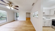This thoughtfully laid-out 1-bedroom, 1-bathroom unit offers a bright, clean, and functional living environment across a single floor. Light-toned hardwood flooring flows consistently throughout the space, creating a cohesive and airy feel from room to room.

The combined kitchen and living area forms the heart of the unit. The kitchen is equipped with stainless steel appliances — including a refrigerator, electric range, and over-the-range microwave — complemented by gray shaker-style cabinetry and light countertops. A pass-through window connects the kitchen to the adjacent living area, enhancing the open feel. The living room benefits from a ceiling fan and access to an outdoor balcony through sliding glass doors, allowing natural light and outdoor views to define the space.

The bedroom is a well-proportioned retreat featuring a ceiling fan, a window with outdoor tree views, and its own access to the balcony. A dedicated closet provides practical storage. The bathroom is clean and functional, featuring a white vanity with ample counter space, a tub/shower combination, and hardwood-style flooring that ties the room together.

Throughout the unit, textured ceilings, white walls, and consistent finishes contribute to a neutral, move-in-ready aesthetic. Ceiling fans in multiple rooms ensure comfort, while the balcony access and windows provide pleasant natural light and outdoor connectivity.