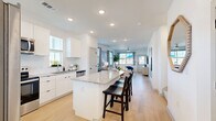 Located at 1392 E Bonds Ranch Rd in Fort Worth, TX, this two-story home offers a thoughtfully designed layout spread across two floors. The main floor, which comprises the majority of the home's footprint, centers around an open-concept kitchen, dining, and living area filled with natural light. The kitchen is outfitted with crisp white cabinetry, granite countertops, a large center island with bar seating, stainless steel appliances, and a tile backsplash — all complemented by light wood-look flooring that flows seamlessly into the living room. The living room features multiple windows that bathe the space in natural light and offer views of the surrounding neighborhood. A pantry, utility room, and laundry area add practical convenience on the main level. Upstairs, three bedrooms are accompanied by well-appointed bathrooms, including a primary suite with its own closet. Additional bedrooms offer double-door closets and soft carpet flooring. The bathrooms feature granite-topped vanities and clean white finishes, with options including a glass-enclosed walk-in shower and a full tub-shower combination. Outside, a private fenced patio provides a concrete seating area with a dining set alongside a rubber-surfaced play zone with a swing set, making it an ideal outdoor retreat.