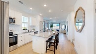 Located at 1392 E Bonds Ranch Rd in Fort Worth, TX, this two-story home offers a thoughtfully designed layout spread across two floors. The main floor, which comprises the majority of the home's footprint, centers around an open-concept kitchen, dining, and living area filled with natural light. The kitchen is outfitted with crisp white cabinetry, granite countertops, a large center island with bar seating, stainless steel appliances, and a tile backsplash — all complemented by light wood-look flooring that flows seamlessly into the living room. The living room features multiple windows that bathe the space in natural light and offer views of the surrounding neighborhood. A pantry, utility room, and laundry area add practical convenience on the main level. Upstairs, three bedrooms are accompanied by well-appointed bathrooms, including a primary suite with its own closet. Additional bedrooms offer double-door closets and soft carpet flooring. The bathrooms feature granite-topped vanities and clean white finishes, with options including a glass-enclosed walk-in shower and a full tub-shower combination. Outside, a private fenced patio provides a concrete seating area with a dining set alongside a rubber-surfaced play zone with a swing set, making it an ideal outdoor retreat.