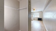 Located at 1620 N Grant St in Denver's Capitol Hill neighborhood, this compact one-bedroom, one-bathroom unit offers a functional and straightforward layout across a single floor. The main living area features light hardwood flooring that runs throughout, lending warmth and continuity to the space. A ceiling fan is centrally mounted overhead, while a classic cast-iron radiator provides supplemental heating beneath a window dressed with vertical blinds, allowing natural light to filter in. A full-size refrigerator is positioned within the living area, reflecting the unit's efficient use of space. An open closet with a hanging rod offers convenient storage directly off the main room. The kitchen includes marble-style countertops that wrap around to provide ample prep space, white cabinetry below, open shelving above, and a deep apron-style sink beneath a window overlooking the exterior brick facade. The bathroom is tiled and equipped with essential fixtures. The textured walls throughout give the unit character consistent with its vintage building origins. This unit is well-suited for those seeking a straightforward, no-frills living space in a walkable Denver neighborhood close to dining, transit, and city amenities.