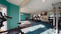 This fitness center is designed to support a comprehensive workout experience within a single, thoughtfully organized floor. The space is divided into distinct functional zones, each catering to different exercise disciplines. The cardio area houses Star Trac treadmills, an elliptical trainer, and a stationary cycle, positioned beneath a wall-mounted flat-screen television for entertainment during workouts. A built-in water station with a hydration dispenser is conveniently located nearby. Adjacent to the cardio zone, a strength training section features a multi-function cable machine and weight bench, accompanied by motivational athletic murals that energize the environment. A dedicated stretching and flexibility area includes stability balls, resistance bands, and yoga mats, set beside large windows that invite generous natural light. The flooring throughout consists of patterned carpet tiles in teal and grey tones, contributing to the space's vibrant aesthetic. Bold teal accent walls punctuate the interior alongside neutral cream and grey tones, creating an energetic yet balanced atmosphere. Recessed lighting supplements the abundant daylight streaming through multiple windows and glass sliding doors, which open to views of an outdoor pool area, seamlessly connecting the interior to the exterior amenities.