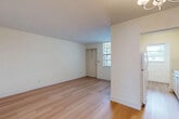 Located at 6460 Taft St in Hollywood, FL, this one-bedroom, one-bathroom residence offers a practical and well-organized single-floor layout. Light wood laminate flooring runs throughout the unit, creating a warm, cohesive feel across all rooms. The combined living and dining area is bright and open, with neutral white walls, a textured ceiling, and natural light filtering in through windows. A chandelier accents the dining area, adding a subtle decorative touch. The kitchen features white cabinetry, light countertops, a stainless steel sink, a white range, and a window that brings in additional natural light — providing a clean and functional cooking space. The bedroom is a comfortable size, with a window fitted with horizontal blinds offering outdoor views and natural light. Multiple closets throughout the unit provide generous storage options. The bathroom includes a full tub/shower combo with classic white tile accented by a navy blue tile border, a toilet, and a window for ventilation. A hallway connects the main living spaces efficiently, and the unit also includes access to a private patio, ideal for enjoying the South Florida climate. Overall, the space presents a clean, move-in ready environment with a straightforward, functional design.