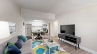 Located at 15300 West Colonial Drive in Winter Garden, Florida, this two-bedroom, single-floor unit offers a well-organized and functional layout designed to maximize every square foot. The open-concept living, dining, and kitchen area serves as the heart of the home, creating a seamless flow between spaces. The kitchen is equipped with stainless steel appliances, including a refrigerator and range, complemented by crisp white cabinetry and a clean, modern aesthetic. The dining area sits adjacent to the kitchen, providing a convenient and connected space for meals. The living room receives natural light through a window dressed with grayish curtains and features wood-look flooring that extends throughout the unit, adding warmth and cohesion. The primary bedroom offers a comfortable retreat with a ceiling fan, a natural-light window, and wood-look flooring. A second bedroom provides additional flexibility for guests or a home office. The bathroom is finished with a white vanity and a tub-shower combination. Additional practical spaces include a laundry area, a hallway, and two closets for ample storage. Textured ceilings and neutral wall tones throughout contribute to a light and airy ambiance.