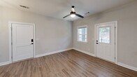 Located at 601 Outlook Dr in Grovetown, GA, this well-appointed one-bedroom, one-bathroom home offers a thoughtfully designed single-floor layout with modern finishes throughout. Wood-look plank flooring flows consistently across every room, contributing to a clean, cohesive aesthetic.

The combined kitchen and living area forms the heart of the home. The kitchen is outfitted with white shaker-style cabinetry, granite-look countertops, a stainless steel refrigerator, range, microwave, and dishwasher — providing a fully functional and visually appealing cooking space. The adjoining living area benefits from natural light streaming through windows framing views of lush greenery, and is equipped with a ceiling fan for comfort.

The spacious bedroom comfortably accommodates a full suite of furniture and features multiple windows that invite ample natural light, along with a ceiling fan. A dedicated walk-in closet off the bedroom offers wire shelving for organized storage. The full bathroom includes a tub/shower combination with clean white surrounds and warm-toned hardware.

Throughout the home, neutral wall tones, white trim, and consistent flooring create a bright, move-in-ready environment. Two exterior entry points in the living area enhance accessibility and connectivity to the outdoors.