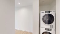 Located on the 10th floor at 351 Marin Blvd in Jersey City's vibrant waterfront district, this one-bedroom, one-bathroom residence offers a clean, modern aesthetic with an efficient and well-considered layout. Light wood flooring flows throughout the unit, complementing the crisp white walls and creating a bright, contemporary atmosphere.

The open-concept kitchen and living area serves as the heart of the home. The galley-style kitchen is outfitted with stainless steel appliances, including a refrigerator, electric range, microwave, and dishwasher. A sleek island with a dark stone countertop and undermount sink anchors the space, while white cabinetry with modern hardware and a subway tile backsplash add a polished finish. Recessed and linear ceiling lighting completes the kitchen's modern look.

The living area features expansive floor-to-ceiling windows on two walls, framing sweeping views of the Jersey City skyline and surrounding neighborhood, flooding the space with abundant natural light.

The bedroom is a comfortable, well-proportioned retreat with large windows that continue the panoramic urban views. The bathroom features large-format tile flooring, a soaking tub with tile surround, a vanity with storage, and a well-lit mirror. The unit's elevated position enhances both the sense of openness and the quality of the views throughout.
