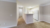 Located at 100 River Ridge Dr in Canton, GA, this well-appointed 2-bedroom, 2-bathroom single-floor residence offers a thoughtfully designed layout across a comfortable footprint. The kitchen is equipped with white cabinetry, ample counter space, a full suite of white appliances, and a peninsula that opens toward the combined dining and living area — a layout that encourages easy flow between spaces. A pendant light fixture anchors the transition zone, while light wood-style flooring runs throughout the kitchen and wet areas.

The combined dining and living room provides generous open space with plush carpeting, creating a warm and inviting atmosphere. A hallway connects the main living areas to the private quarters, where two well-sized bedrooms feature soft carpet flooring and windows that bring in natural light with views of surrounding greenery. The spacious primary bedroom includes a dedicated closet, adding practical storage.

Both bathrooms are finished with light, neutral tones. One features a tiled tub/shower combination with classic chrome fixtures, while the other includes a vanity with ample counter space and wood-style flooring. A dedicated laundry room with washer/dryer hookups, wire shelving, and hard surface flooring adds everyday convenience. A private balcony completes the unit, offering an outdoor retreat.