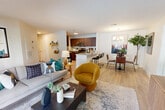 Located at 12201 Pender Creek Circle in Fairfax, VA, this single-floor, 2-bedroom, 1-bathroom residence offers a thoughtfully designed open-concept layout. Light hardwood flooring flows throughout the main living areas, creating a cohesive and airy feel. The living room is bright and inviting, anchored by large sliding glass doors that open onto a private balcony overlooking lush greenery — filling the space with abundant natural light and outdoor views.

The kitchen is a standout feature, outfitted with rich walnut-toned cabinetry, granite countertops, a white subway tile backsplash, and a full suite of stainless steel appliances. A peninsula with bar seating connects the kitchen seamlessly to the dining and living areas, making it ideal for entertaining.

The primary bedroom is generously sized, with plush carpeting, large windows framing outdoor views, and ample closet space. The second bedroom offers similar comfort and versatility. The full bathroom features wood-look flooring, a tub-shower combination, and clean, modern finishes throughout.

Additional highlights include a dedicated utility room, multiple closets for storage, and a well-proportioned hallway connecting all rooms. The overall ambiance is modern and welcoming, balancing functional design with contemporary style.