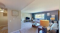 Located at 969 W Main Rd in Middletown, Rhode Island, this one-bedroom, one-bathroom residence offers a thoughtfully arranged single-floor layout that makes efficient use of its space. The living room serves as the heart of the home, featuring soft carpeting, a bold navy accent wall, and a large window that fills the room with natural light and views of the surrounding greenery. The open, relaxed atmosphere is well-suited for both everyday living and entertaining.

The kitchen is equipped with warm wood cabinetry extending to the ceiling for ample storage, stone-look countertops, and black appliances including a full-size refrigerator, range, and dishwasher. Light wood-style flooring adds a clean, practical touch to the space.

The bedroom is a comfortable retreat with plush carpeting, large windows overlooking lush outdoor scenery, and soft neutral tones that create a calm ambiance. A dedicated walk-in closet with a full-length mirror and a full-length hanging rod provides generous storage just steps from the bedroom.

The bathroom features a white vanity with granite-style countertops, a tub-shower combination, light wood-look flooring, and open shelving for additional storage. The cohesive coastal-inspired design throughout the residence lends the space a serene, welcoming character.