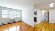 This well-appointed one-bedroom, one-bathroom residence in Perth Amboy, NJ offers a thoughtfully designed single-floor layout with an efficient use of space throughout. Gleaming hardwood floors flow seamlessly across the living room, bedroom, and connecting areas, lending warmth and continuity to the interior.

The open living room is bright and welcoming, featuring natural light from large windows with blinds and a wall-mounted air conditioning unit alongside baseboard heating for year-round comfort. The space connects to a galley-style kitchen, which is outfitted with rich dark wood cabinetry, granite countertops, a marble-style tile backsplash, stainless steel appliances including a gas range and refrigerator, and a undermount sink — a well-equipped space for home cooking.

The bedroom is generously proportioned, offering dual closets with sliding and hinged doors for ample storage, along with windows that bring in natural light and views of the surrounding greenery. Light-toned hardwood floors continue throughout.

The bathroom is elegantly finished with marble-style wall tile surrounding a full soaking tub with a glass panel, complemented by a dark wood vanity with a granite countertop and chrome fixtures, creating a clean, refined aesthetic. This residence combines functional design with quality finishes throughout.