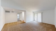 Located at 3700 Kingwood Drive in the Kingwood area of Houston, Texas, this single-floor residence offers a clean, functional layout with a bright and neutral aesthetic throughout. The spacious living area is finished with warm-toned carpeting and features large windows fitted with vertical blinds, allowing ample natural light while providing outdoor views and direct access to a private balcony. The open flow connects the living space to a hallway leading to the remaining rooms.

The galley-style kitchen is well-appointed with rich dark wood cabinetry, granite countertops, a stainless steel double-basin sink, and black appliances including a range and refrigerator. Wood-look flooring and a window overlooking the balcony complete the kitchen's practical yet polished character.

The bedrooms are carpeted and bathed in natural light from standard windows, with ceiling fans providing comfort. The primary bedroom includes closet space with built-in shelving and rod storage. Additional rooms offer versatile, open layouts suited to a variety of uses.

The bathroom features a tub-shower combination with striking marble-style wall surrounds, chrome fixtures, and clean white finishes. Throughout the residence, white walls and consistent flooring choices create a cohesive, move-in-ready environment.