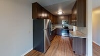 Located at 175 McKnight Rd N in Saint Paul, Minnesota, this single-floor unit offers a well-organized layout designed for comfortable everyday living. The open living area features hardwood-style flooring and a ceiling fan, flowing seamlessly into a dedicated carpeted space bathed in natural light from a large picture window that frames lush green outdoor views. Baseboard heating is present throughout, ensuring year-round comfort.

The kitchen is a standout feature, appointed with rich dark wood cabinetry, granite-look countertops, and a full suite of stainless steel appliances including a refrigerator, range, and microwave. Wood-style flooring ties the kitchen and living areas together cohesively.

The bedrooms are generously sized with plush carpeting underfoot, ceiling fans, and wide windows offering serene outdoor views. A walk-in closet provides ample storage in the primary bedroom. The bathroom is clean and functional, featuring a tiled tub-shower combination with chrome fixtures.

A central hallway with dark hardwood-style flooring connects all areas of the unit, providing a smooth transition between spaces. Textured ceilings are present throughout, and the neutral color palette creates a bright, welcoming ambiance across every room.