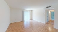 Located at 2505 Quail Ridge Drive in Plainsboro, NJ, this single-floor residence offers two bedrooms and one bathroom within a well-organized layout. The living area features light hardwood-style flooring and crisp white walls, creating a bright and clean atmosphere. A sliding glass door fitted with vertical blinds allows natural light to fill the space while providing outdoor access. A pendant light fixture is positioned in the adjoining dining area, which shares the same warm flooring and connects seamlessly to the kitchen.

The kitchen is efficiently designed with warm wood cabinetry, gray countertops, a stainless steel sink, a dishwasher, and a range, offering practical functionality in a compact footprint. Both bedrooms are carpeted and finished in neutral tones. One bedroom features a sliding closet and a window overlooking the surrounding greenery, while the other includes a window with blinds and a private door entry. The full bathroom is cleanly appointed with tile flooring, a tub-shower combination, a vanity with a sink, and a wall mirror. Overall, the residence presents a clean, functional, and move-in ready environment.