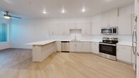Located at 6540 W Arby Ave in Las Vegas, NV, this one-bedroom, one-bathroom unit offers a thoughtfully designed single-floor layout with a clean, modern aesthetic throughout. Light hardwood-style flooring runs continuously across the entire space, creating a cohesive and bright interior.

The open-concept kitchen serves as the centerpiece of the living area, featuring crisp white cabinetry with sleek hardware, a white countertop peninsula that doubles as a breakfast bar, and a full suite of stainless steel appliances including a refrigerator, range, microwave, and dishwasher. Recessed lighting illuminates the kitchen and living area, enhancing the open, airy feel of the space.

The bedroom is a comfortable, well-proportioned room equipped with a ceiling fan, a window with blinds that invites natural light and outdoor views, and direct access to both a closet and the bathroom. The bathroom is finished in an all-white palette, featuring a single-sink vanity with white cabinetry, a walk-in shower with built-in shelving, and consistent hardwood-style flooring. The overall design of this unit is clean, minimalist, and move-in ready, making efficient use of its well-organized floor plan.