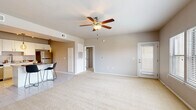 Located at Crown at Lone Oak in Oklahoma City, OK, this single-floor, 3-bedroom, 3-bathroom home offers a well-designed open-concept layout. The living room is a spacious, carpeted area anchored by a ceiling fan and filled with natural light from a large window. It flows seamlessly into the kitchen and dining area, which features tile flooring, white cabinetry, stainless steel appliances including a refrigerator, range, and microwave, a tile backsplash, and a breakfast bar with pendant lighting overhead — ideal for casual dining.

The primary bedroom is generously sized, featuring plush carpet, a ceiling fan, and a wide triple-window arrangement that brings in abundant natural light. Its en-suite bathroom includes a dual-sink vanity with white cabinetry, tile flooring, and a well-lit mirror. The additional bedrooms are equally well-appointed with ceiling fans, carpeted floors, and windows for natural light. Secondary bathrooms include a single-sink vanity with white cabinetry and a shower-tub combination. Two closets provide ample storage throughout the home. The neutral color palette and consistent finishes give this home a clean, move-in-ready feel.