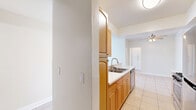Located at 18540 Citronia St in Los Angeles, CA, this 2-bedroom, 3-bathroom unit offers a thoughtfully arranged single-floor layout with a variety of functional spaces. The galley-style kitchen features warm honey-toned cabinetry, stainless steel appliances including a gas range, microwave, and refrigerator, white countertops, and light tile flooring throughout. A pass-through opening connects the kitchen to the combined living and dining area, which is finished with light wood-style flooring and transitions seamlessly between spaces. The living area is highlighted by a tiled fireplace and a window and door that fill the room with natural light, leading to an outdoor balcony. The primary bedroom offers wood-style flooring, a mirrored sliding closet, and direct access to an en-suite bathroom. The second bedroom also features wood-style flooring and includes multiple closet options. Three full bathrooms provide ample convenience, with at least one featuring a full tub-shower combination. With five closets distributed throughout, storage is plentiful. Hallways finished in light tile connect the various rooms, contributing to a clean, cohesive aesthetic throughout the unit.
