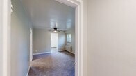 Located at 275 North Ave in Washington, PA, this single-floor unit offers four bedrooms, one bathroom, a kitchen, hallway, and entrance. The layout is efficiently organized, with a central hallway connecting the main living areas. The bedrooms are carpeted and finished in neutral tones, with several rooms featuring classic cast-iron radiators for heating. The primary bedroom is notably spacious and includes two windows that bring in natural light, a ceiling fan, and a radiator — offering both comfort and functionality. Additional bedrooms are well-proportioned with carpet flooring and clean, neutral walls. The kitchen features white cabinetry, granite-look countertops, a stainless steel sink, and warm hardwood-style flooring, with a window providing natural light and outdoor views. The bathroom is fitted with a full tub-shower combination, white surround walls, and a window for ventilation. Throughout the unit, white trim and soft neutral wall colors create a clean, consistent aesthetic. The space is practical and well-maintained, offering a comfortable living environment suited for multiple occupants.