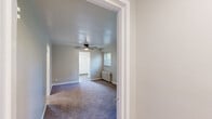 Located at 275 North Ave in Washington, PA, this single-floor unit offers four bedrooms, one bathroom, a kitchen, hallway, and entrance. The layout is efficiently organized, with a central hallway connecting the main living areas. The bedrooms are carpeted and finished in neutral tones, with several rooms featuring classic cast-iron radiators for heating. The primary bedroom is notably spacious and includes two windows that bring in natural light, a ceiling fan, and a radiator — offering both comfort and functionality. Additional bedrooms are well-proportioned with carpet flooring and clean, neutral walls. The kitchen features white cabinetry, granite-look countertops, a stainless steel sink, and warm hardwood-style flooring, with a window providing natural light and outdoor views. The bathroom is fitted with a full tub-shower combination, white surround walls, and a window for ventilation. Throughout the unit, white trim and soft neutral wall colors create a clean, consistent aesthetic. The space is practical and well-maintained, offering a comfortable living environment suited for multiple occupants.
