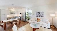 Located at 4220 Coasterra Dr in Fort Myers, FL, this two-story residence offers a well-designed layout spread across two floors. The main level features an open-concept living, dining, and kitchen area bathed in natural light, with warm hardwood-style flooring throughout. The kitchen is outfitted with stainless steel appliances, white shaker cabinetry extending to the ceiling, and a movable butcher-block island that adds functional workspace. The dining area sits adjacent to the kitchen, framed by a window overlooking the surroundings. The living room opens directly to a patio through sliding glass doors, seamlessly connecting indoor and outdoor living. A half bathroom is conveniently located on this floor. Upstairs, the spacious primary bedroom features plush carpeting, a large window with outdoor views, and generous closet space. A second well-appointed bedroom and a loft provide additional flexibility. The bathrooms are finished with clean white tile, elongated vanities with quartz countertops, and walk-in showers. A dedicated laundry area and multiple closets add to the home's practicality. With two patios, ample storage, and a bright, coastal-modern aesthetic, this home is thoughtfully designed for comfortable Florida living.