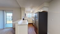 Located at 3333 Monument Rd in Jacksonville, FL, this single-floor residence offers a well-designed layout with a range of updated finishes throughout. The open-concept living and dining area is anchored by a fireplace flanked by built-in shelving, vaulted ceilings, and a ceiling fan, creating a comfortable and airy atmosphere. Soft carpet underfoot extends through the living spaces and bedrooms, adding warmth to the neutral color palette.

The kitchen is a standout feature, showcasing white cabinetry, marble-look countertops, a stainless steel appliance suite including a French door refrigerator and dishwasher, and wood-look flooring. A peninsula with bar-top seating connects the kitchen seamlessly to the living area, while pendant lighting and a window above the sink bring in natural light.

The bedrooms are generously sized, each equipped with ceiling fans and large windows fitted with blinds that allow for ample natural light and privacy. The bathrooms are clean and functional, featuring white tiled tub-shower combinations, wood-look flooring, and modern white vanities. The overall design is cohesive, combining practical updates with a bright, neutral aesthetic throughout.
