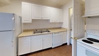 Located at 133A Connecticut Ave in Stamford, Connecticut, this two-floor residence offers a clean, functional layout with thoughtfully designed spaces across both levels. The entry area welcomes visitors through a distinctive green front door, opening into a carpeted living space bathed in natural light from a window overlooking the surrounding neighborhood. Neutral white walls and dark baseboards create a crisp, consistent aesthetic throughout the home. The kitchen is well-equipped, featuring white cabinetry extending to the ceiling for ample storage, light granite-style countertops, a double stainless steel sink, a dishwasher, and wood-look flooring that adds warmth to the space. Multiple carpeted rooms offer flexible use, each outfitted with windows fitted with blinds that provide views of the outdoors and allow natural light to filter in. The full bathroom is finished in a clean, all-white palette with a bathtub and shower combination, a pedestal sink, and wood-look tile flooring, accented by a window for ventilation and light. The overall ambiance of the home is bright, neutral, and move-in ready, with a straightforward layout that makes efficient use of space across its two floors.