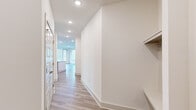 Located at 89 Caldwell Drive in Belmont, NC, this well-appointed 2-bedroom, 2-bathroom home offers a thoughtfully designed single-floor layout with modern finishes throughout. The open-concept kitchen and living area serves as the heart of the home, featuring a large center island with white quartz countertops, gray shaker-style cabinetry, a classic subway tile backsplash, and a full suite of stainless steel appliances. Light wood-style flooring runs throughout the main living areas, complementing the bright, neutral color palette. The living room is bathed in natural light from multiple large windows and offers direct access to an outdoor space via a glass-panel door. The primary bedroom is generously sized, complete with plush carpeting, a ceiling fan, built-in shelving, and access to a walk-in closet. Its en-suite bathroom features a dual-sink vanity with quartz countertops, hardwood-style flooring, and a tiled walk-in shower. The secondary bedroom also offers carpet flooring, a ceiling fan, and ample natural light. A second full bathroom includes a tub-shower combination with tiled surround and a single vanity. Recessed lighting and clean white walls throughout create a bright, modern ambiance across the entire home.