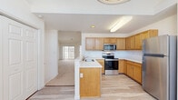 Located at 2814 Brooke Cir in Watervliet, NY, this one-bedroom, one-bathroom residence offers a well-organized and functional single-floor layout. The kitchen is a standout feature, equipped with warm oak cabinetry, stainless steel appliances including a refrigerator, range, and over-the-range microwave, light wood-style flooring, and a peninsula with a built-in sink that opens toward the living area. This open-concept flow creates an inviting and connected living space. The living area is highlighted by soaring vaulted ceilings and a large sliding glass door that draws in abundant natural light. The bedroom provides a comfortable, carpeted retreat with a window and easy access to a closet for additional storage. The full bathroom is finished with white tile flooring, a single-sink oak vanity with mirror, and a full soaking tub with shower. Throughout the residence, a neutral white color palette and plush carpeting in the living and bedroom areas contribute to a clean, bright ambiance. A staircase is also included in the layout, adding structural dimension to the space. The overall design is practical and well-appointed, making it an efficient and comfortable home.