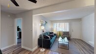 Located at 3803 Half Turn Rd in Colorado Springs, Colorado, this single-floor residence offers a well-organized and thoughtfully updated living space. The open living area is highlighted by durable wood-style flooring, a textured ceiling, and a ceiling fan, creating a comfortable and inviting atmosphere. A standout feature of the living room is the white-painted brick fireplace, which adds a classic architectural touch alongside large windows fitted with vertical blinds that allow natural light to fill the room.

The kitchen is efficiently designed with white cabinetry, a light countertop, and black appliances including a refrigerator and range. A breakfast bar with seating connects the kitchen to the living and dining area, enhancing the functional flow of the space.

The bedroom is generously sized, featuring wood-style flooring, a large window that brings in natural light, a textured ceiling, and ample closet access via a hallway. The space accommodates a full-sized bed comfortably and maintains a calm, neutral aesthetic.

The bathroom is cleanly appointed with a white vanity, a large mirror, a tub-shower combination, and wood-style flooring that carries through from the rest of the home. Throughout the residence, neutral wall tones and consistent flooring create a cohesive and modern living environment.